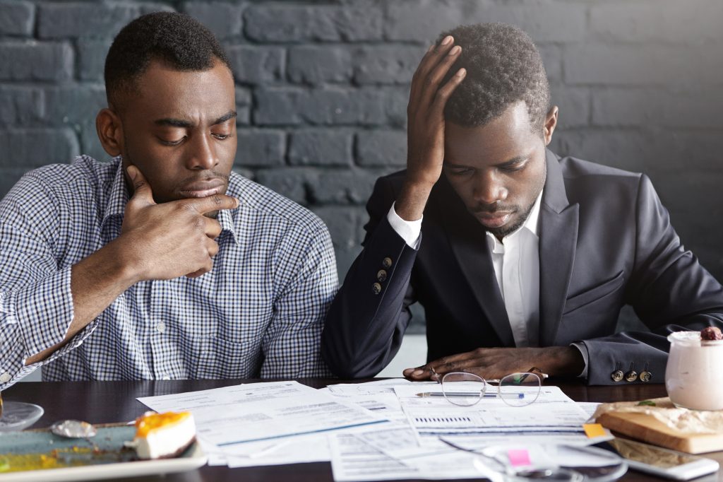 two-tired-depressed-african-american-businessmen-doing-paperwork(1)